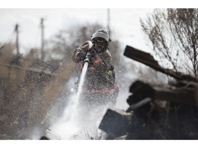 Firefighters put out a grass fire along the railway tracks near the intersection of 19th Street West and Avenue M South on Thursday, April 20, 2017. (Saskatoon StarPhoenix/Liam Richards)