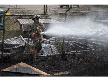 Saskatoon firefighters put out a grass fire along the railway tracks near the intersection of 19th Street West and Avenue M South in Saskatoon on April 20, 2017.