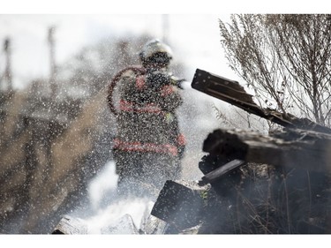 Saskatoon firefighters put out a grass fire along the railway tracks near the intersection of 19th Street West and Avenue M South in Saskatoon on April 20, 2017.