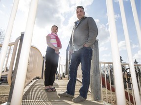 Torin (L) and her father Randal Wunder-Buhr stand for a photo at St. Philip School playground where Torin broke her arm last year in Saskatoon, SK on Thursday, April 20, 2017. (Saskatoon StarPhoenix/Kayle Neis)