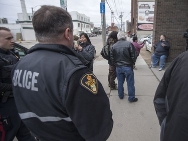 Saskatoon Police look on as Stan Goertzen, former president of the Saskatoon City Police union, right, speaks with Songgirl Reyes-Starr, a relative of Neil Stonechild, outside of the Army, Navy & Airforce Veterans building.