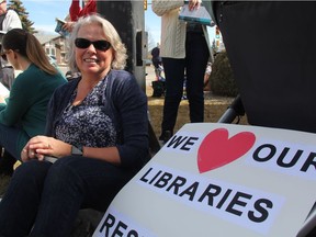 Sitting outside of MLA and Education Minister Don Morgan's constituency office on Friday, Cheryl Erlandson, reads quietly in protest of cuts to the province's libraries. She fears programs offered by the Saskatoon Public Library, like its Book Club in a Bag program, which helps people organize and launch book clubs will be jeopardized, as the SPL is facing a budget shortfall of $800,000. (Morgan Modjeski/The Saskatoon StarPhoenix)