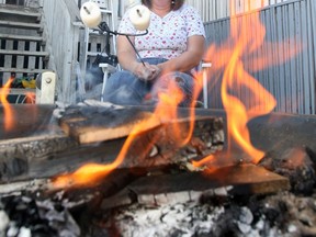 A person roasts a marshmallow in this PNG file photo.