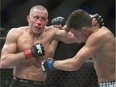 FILE - In this March 16, 2013, file photo, Georges St. Pierre, left, lands a blow to Nick Diaz, from the United States, during their UFC 158 welterweight mixed martial arts title fight in Montreal.