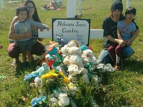 Mother of Nikosis Jace Cantre Alyssa Bird, left, and his father, Kashtin Cantre, can be seen at the gravesite for baby Nikosis with his two older siblings during a celebration of Nikosis' heavenly first birthday on May 18, 2017. Family members of Baby Nikosis gathered at the Longman Cemetery on the George Gordon First Nation to celebrate his life, singing happy birthday and releasing balloons into the air as a way to honour the baby boy who was killed on July 3, 2016.