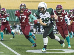 Saskatoon Valkyries running back Sarah Wright runs while the Regina Riot chase during a game at old Mosaic Stadium.