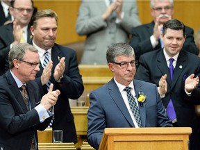 Premier Brad Wall, left, applauds as Ken Krawetz delivers his final provincial budget as finance minister on March 18, 2015.