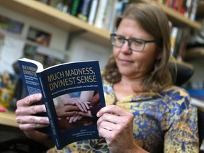 Lori Hanson, associate professor of Community Health and Epidemiology at the University of Saskatchewan, takes a look at Much Madness, Divinest Sense. (Michelle Berg / Saskatoon StarPhoenix)
