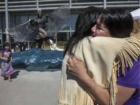 Gwenda Yuzicappi, right, is comforted during the unveiling of a missing and murdered indigenous women monument at the entrance to the Saskatoon Police headquarters in Saskatoon on Friday, May 5, 2017. Yuzicappi's daughter, Amber Redman, went missing in 2005, and her remains where found in 2008. The monument is named Wicanhpi Duta Win, Amber Redman's Dakota name. It was inspired by her and her dancing.