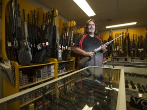 North Pro Sports sales associate Michael Kincade holds a rifle inside the Sutherland-area store.