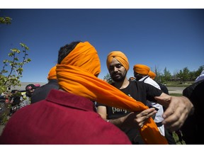 Aman Preet ties headwear on Suknwinder Singh during a Sikh Parade celebrating Vaisakhi at Wallace Park in Saskatoon, SK on Saturday, May 27, 2017. (Saskatoon StarPhoenix/Kayle Neis)