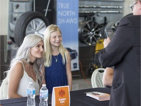 Retired Canadian soccer player Kaylyn Kyle sits for a photo with Sierra Kimpton, age 8, during a community autograph event at the Acura Centre in Saskatoon, June 13, 2017.