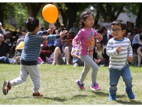 (L-R) Leo Huang, Li Yuan Pan and Yuto Enomoto run around the dance area of the PotashCorp Club Jazz Free Stage during the Stone Frigate Big Band performance at the SaskTel Saskatchewan Jazz Festival on June 25, 2017.