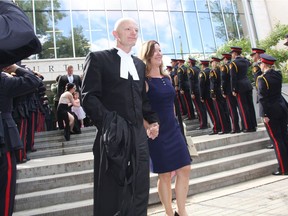 Bruce Gordon, left, and his wife Chris Gordon, are saluted by member of the Saskatoon Police Service as they leave Saskatoon's Court of Queen's Bench on Thursday afternoon. Well known in the community as a volunteer, elite athlete and a former 28-year member of the Saskatoon police, Gordon and his wife received the honour guard salute following a special ceremony where Gordon took his Oath of Office and became a lawyer, a ceremony that was held early due to a cancer diagnosis. (Morgan Modjeski/The Saskatoon StarPhoenix) (Morgan Modjeski/The Saskatoon StarPhoenix).