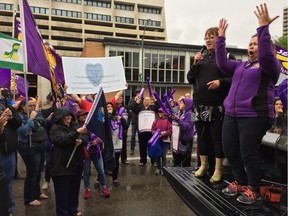 Canadian Labour Congress secretary-treasurer Barbra Byers (left) and SEIU-West president Barbara Cape speak to protesters in the rain outside of Saskatoon's Cabinet Office as they present the Cold Heart Award to the Saskatchewan government on June 22, 2017.