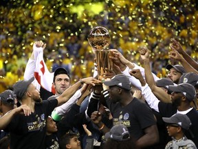 The Golden State Warriors celebrate with the Larry O'Brien Championship Trophy after defeating the Cleveland Cavaliers 129-120 in Game 5 to win the 2017 NBA Finals at ORACLE Arena on June 12, 2017 in Oakland, California.