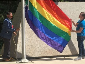 Danny Papadatos, co-chair of the Saskatoon Pride Festival (left) and Scott Eason, a board member of the pride festival, prepare to raise the Pride flag Monday, June 12, 2017 at City Hall.