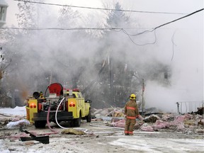 A firefighter looks over the wreckage of a Regina Beach home that exploded in December 2014 after shifting ground caused a natural gas leak.
