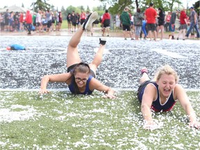 Athletes from Regina and the North Central district play in the hail after a storm during the High School Track and Field Provincial Championships at Griffith Stadium in Saskatoon, SK on Friday, June 2, 2017. (Saskatoon StarPhoenix/Kayle Neis)