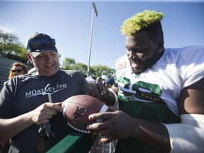 Saskatchewan Roughriders offensive lineman Derek Dennis signs autographs for fans after a mock game at SMF for the Riders Training Camp in Saskatoon on June 3, 2017.