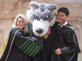 Hayley Wickenheiser and U of S grad Connor Jay get up close with Howler, the Huskies' mascot.