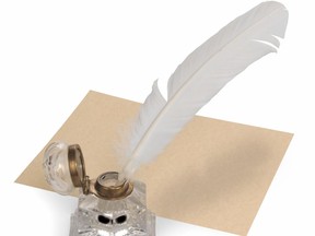 Vintage quill pen, parchment paper and ink well isolated on white with clipping path.