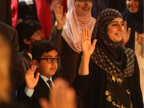 Eight-year-old Zohaib Jabeen and his mother Rukhshanda Jabeen recite the oath of citizenship during their ceremony under the Shakespeare on the Saskatchewan tent in Saskatoon on July 11, 2017.