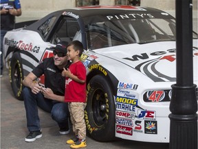 NASCAR Pinty series driver Louis-Phillipe Dumolin gets a photo with Orlando Mendioro, age 4, during an event with other driver Jean-Francois Dumoulin, not pictured, in front of the Delta Bessborough in Saskatoon, SK on Monday, July 24, 2017.