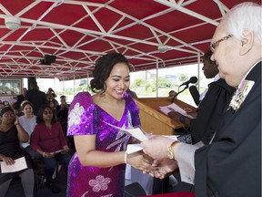 Joanne Buan accepts her proof of Canadian citizenship during a ceremony held on the Lily river boat. Fifteen new Canadians gave the oath of citizenship in Saskatoon, SK on Tuesday, July 25, 2017.