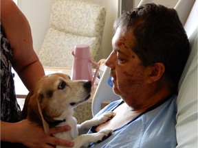 Robert Carignan, a 57-year-old man who was the victim of a violent beating last weekend, can be seen in his St. Paul's Hospital bed with his beloved beagle, Molly on July 27, 2017. On Thursday afternoon, Robert and Molly were reunited for the first time since Robert was pulled from his wheelchair and attacked. Surrounded by friends and family, it was a reunion filled with tears of happiness, emotion and a quickly wagging tail.