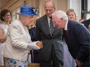 Britain's Queen Elizabeth II, accompanied by Britain's Prince Philip, Duke of Edinburgh, is welcomed by Canada Governor General David Johnston on a visit to Canada House in central London on July 19, 2017, to mark the 150th anniversary of Confederation.
