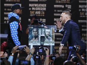 Conor McGregor, right, taunts Floyd Mayweather Jr. while pausing for photos during a news conference at Staples Center on Tuesday, July 11, 2017, in Los Angeles. The two will fight in a boxing match in Las Vegas on Aug. 26. (AP Photo/Jae C. Hong)