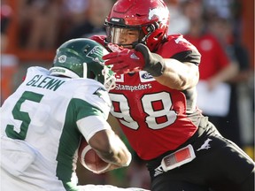Saskatchewan Roughriders quarterback Kevin Glenn, left, is sacked by Calgary Stampeders' James Vaughters during first half CFL football action in Calgary on Saturday July 22, 2017. THE CANADIAN PRESS/Larry MacDougal