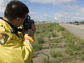 Constable Patrick Barbar uses his radar gun on passing motorists near Tommy Douglas Collegiate and Bethlehem School on Saskatoon's east side in this Saskatoon StarPhoenix file photo.