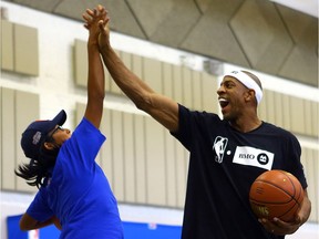 Former Toronto Raptor and NBA star Jerome Williams high fives Colby Bear during a youth clinic at Red Hawk elementary school on Whitecap First Nation as part of the BMO and NBA's Courts Across Canada project on August 1, 2017.
