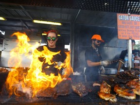 Gator BBQ ribber Alexa Latowiec flips a rack of ribs on the barbecue during Ribfest in Saskatoon on August 6, 2017.