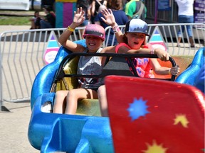 Makayla (left) and Ashlyn (right) Cochrane enjoy one of the Saskatoon Exhibition's many high-speed and spinning rides during Kids' Day.