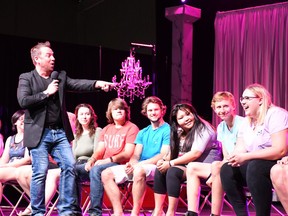 Tyzen the hypnotist, also known as Mark Paley, points to one of his many laughing volunteers on stage at the Saskatoon Exhibition.