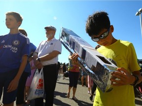 Nine-year-old Jingting Cui watches the partial solar eclipse with his homemade projector outside London Drugs on 8th Street in Saskatoon on August 21, 2017.