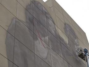 Saskatchewan artist Emmanuel Jarus paints a giant mural on the north side of the First Nations Bank.