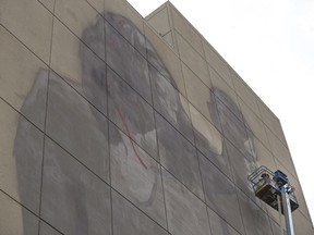 Saskatchewan artist Emmanuel Jarus paints a giant mural on the north side of the First Nations Bank.