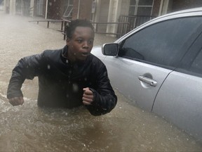 Deleon Gambel, 14, fights the current from the overflow of Buffalo Bayou as he makes his way through floodwaters from Tropical Storm Harvey while checking on neighbors in his apartment complex in Houston, Sunday, Aug. 27, 2017. The remnants of Hurricane Harvey sent devastating floods pouring into Houston Sunday as rising water chased thousands of people to rooftops or higher ground. (AP Photo/LM Otero)