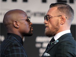 Boxer Floyd Mayweather Jr. (L) and Conor McGregor face off during a media press conference August 23, 2017 at the MGM Grand in Las Vegas, Nevada