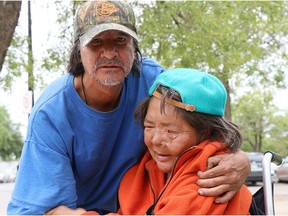 Patrick Lavallee holds Marlene Bird after discussing the theft of Bird's electric scooter.