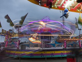 At the Saskatoon Ex, West Coast Amusements light up the midway and a dark cloudy evening, August 10, 2016.
