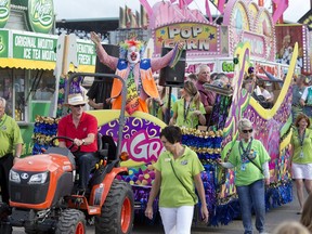 The annual Mardi Gras Parade and Noodles the Clown makes its way through the exhibition food stand road before circling through the midway tossing coloured necklaces to everybody at the Saskatoon Ex at Prairieland Center, August 9, 2016.