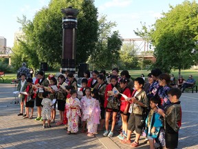 Children from the Japanese Children's Choir sing at the Peace Monument in Rotary Park during a memorial to victims of Hiroshima and Nagasaki in 2014.