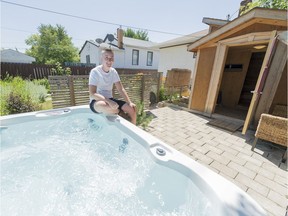 Lorne Gill sits at the edge of a hot tub in the backyard of his home, where he lists some rooms on Airbnb.
