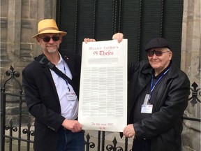 Pastor Ron Bestvater and his father, Rev. JR Bestvater, stand in front of the doors of the Castle Church in Wittenberg, holding as parchment with an English translation of Luther's 95 Theses which are also inscribed on the doors behind them. Photo courtesy of Ron Bestvater