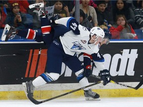 Blades' defenceman Evan Fiala checks Regina Pats' Colby Williams against the boards during first-period action at SaskTel Centre in Saskatoon on January 30, 2017.